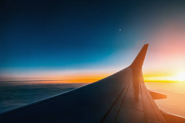 istock Sunset from airplane window view. Aircraft wing from illuminator view 1187683883