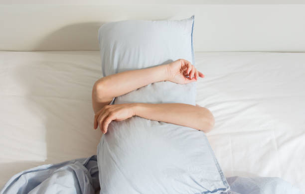 istock Woman sleeping on a white bed 1187684180