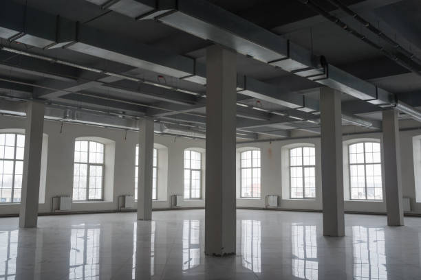 istock Empty open space room in old factory building with rows of columns, big windows and pipes under the beton ceiling 1187686413