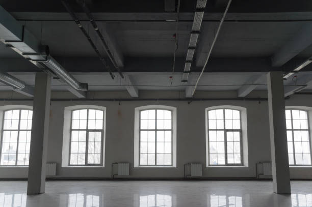 istock Empty open space in old factory building with columns, large windows and pipes under the beton ceiling 1187686423