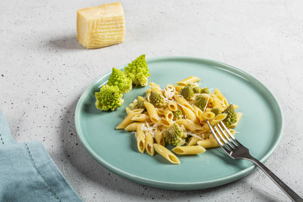 penne pasta mit romanesco kohl auf hellgrauem hintergrund - romanesque broccoli cauliflower cabbage stock-fotos und bilder