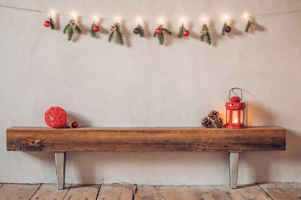 Cozy rustic Christmas composition in a rural house with a lantern and red bauble on an old wooden log stock photo