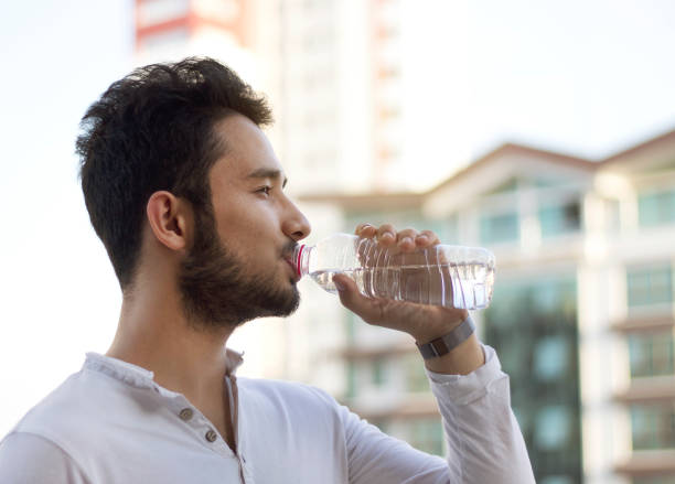 istock close up of a man drinking water from a bottle 1187699816