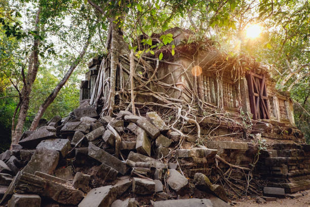 Prasat Beng Mealea in bright rays of the sun that goes down in Angkor Complex, Siem Reap, Cambodia. Unrestored ancient Khmer architecture, lot of its stones lying in great heap