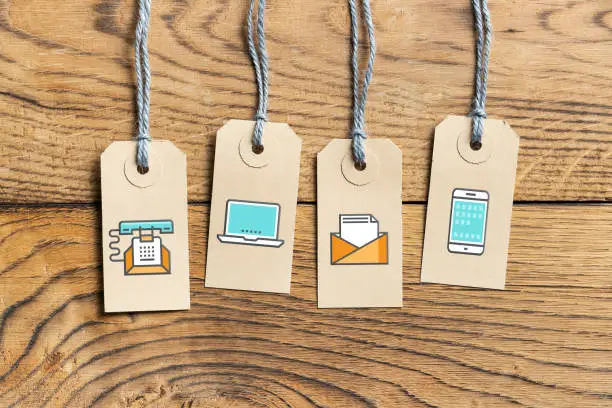 Hangtags with contact option icons on wooden background