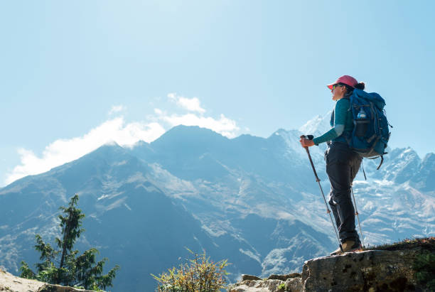 高地順応歩中に山の景色を楽しむトレッキングポールを使用して若いハイカーバックパッカーの女性。エベレストベースキャンプトレッキングルート、ネパール。アクティブバケーションコ� - namche bazaar ストックフォトと画像