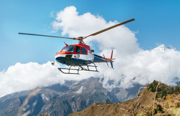 medizinische rettungshubschrauber landung in hohen himalaya-bergen. konzeptbild der sicherheits- und reiseversicherung. - himalayas mountain aerial view mountain peak stock-fotos und bilder
