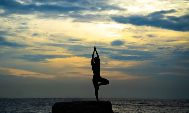 istock woman is practicing yoga at seashore 1187709989