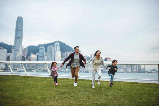 바다 터미널 갑판을 가로 질러 달리는 재미있는 중국 가족 - harbour city 뉴스 사진 이미지