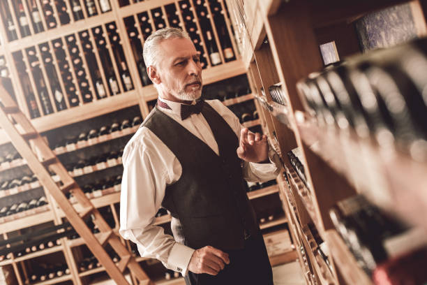 istock Sommelier Concept. Senior man standing choosing wine concerned 1187713113
