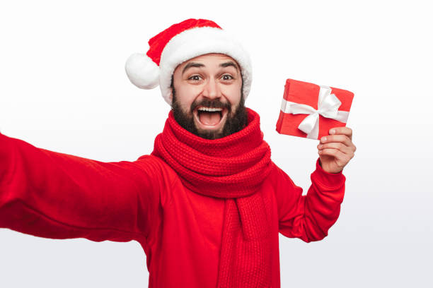 Cheerful man taking selfie with Christmas present