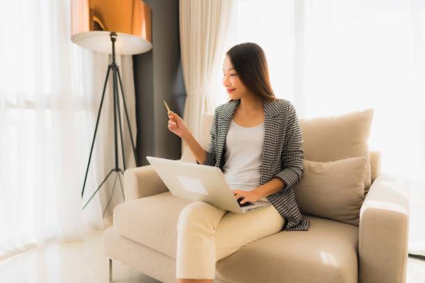 istock Portrait beautiful young asian women using computer laptop or smart and mobile phone with credit card for online shopping 1187734138
