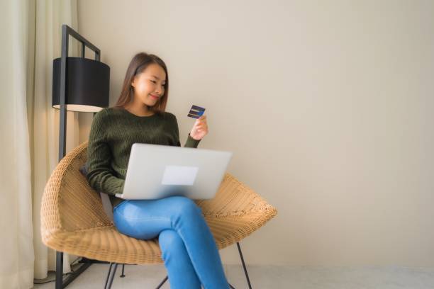 istock Portrait beautiful young asian women using computer laptop or smart and mobile phone with credit card for online shopping 1187734719