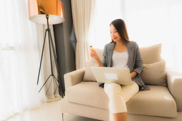 istock Portrait beautiful young asian women using computer laptop or smart and mobile phone with credit card for online shopping 1187735108