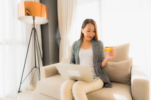 istock Portrait beautiful young asian women using computer laptop or smart and mobile phone with credit card for online shopping 1187735323