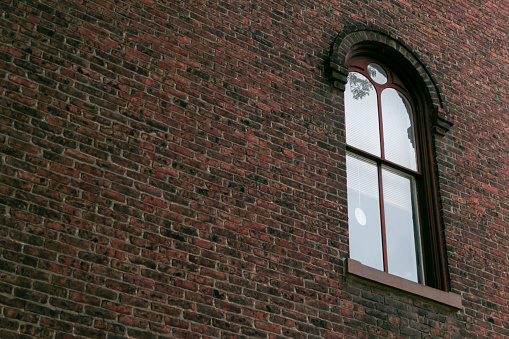Arched window on old brick wall exterior