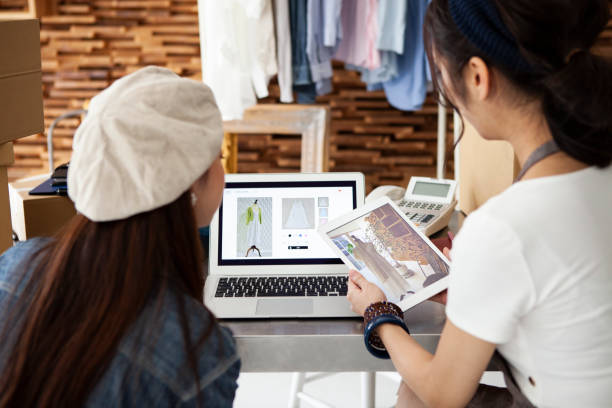 dos mujeres vendiendo ropa para compras en línea - tienda en línea fotografías e imágenes de stock