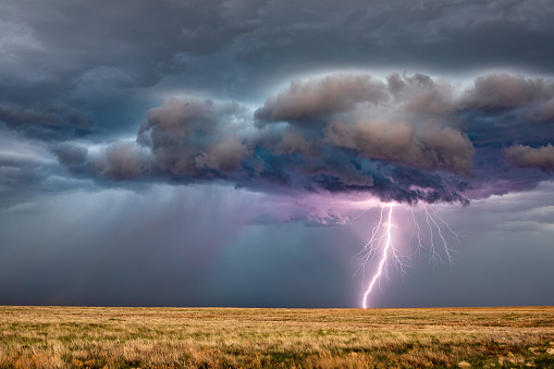 Lightning on background of night sky. Weather and climate. Flash of lightning. Natural disaster. Dark dramatic sky. Storm