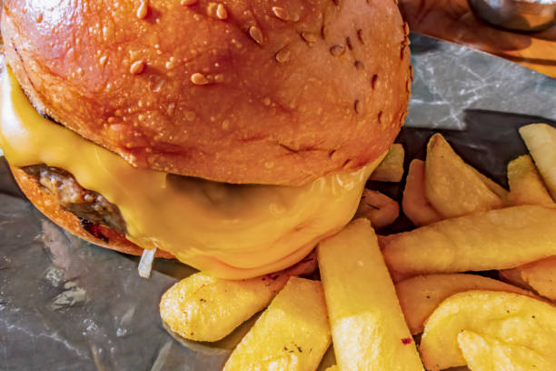istock close up hamburger with cheddar cheese and fried potatoes. 1187751491