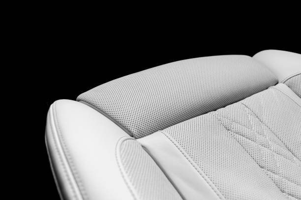 istock White leather interior in car. Perforated white leather comfortable seats with stitching isolated on black background. Modern car interior details. Car detailing. Car inside 1187752749