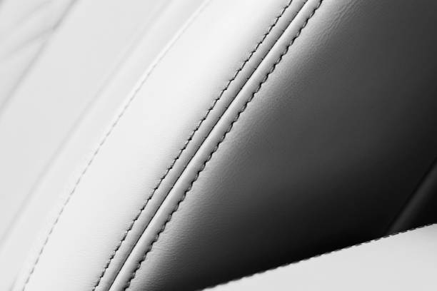 istock White leather interior in car. Perforated white leather comfortable seats with stitching isolated on black background. Modern car interior details. Car detailing. Car inside 1187752917