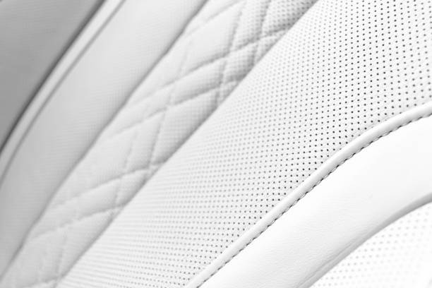istock White leather interior in car. Perforated white leather comfortable seats with stitching isolated on black background. Modern car interior details. Car detailing. Car inside 1187753534