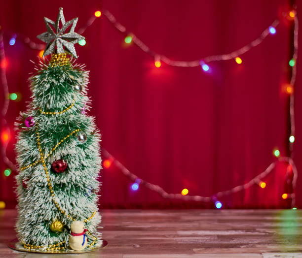 istock Artificial Christmas tree on a red background with garlands with place for text. horizontal 1187756430