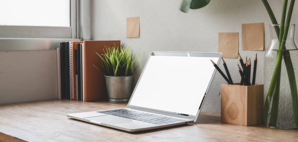 istock Cropped shot of comfortable workspace with blank screen laptop computer and office supplies 1187766545