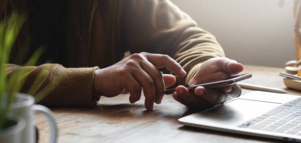 istock Cropped shot of young man using his smartphone while working on his project in comfortable office 1187766585