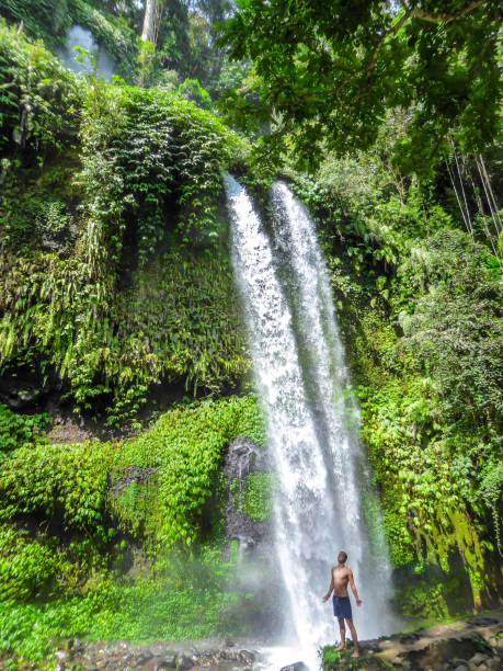 istock Lombok - A man standing under Tiu Kelep waterfall 1187766696