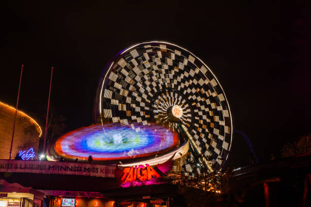 l'evento carnival of light al parco divertimenti linnanmaki. guida la ruota panoramica rinkeli e kehra in movimento, illuminazione notturna, lunga esposizione. - ferris wheel wheel blurred motion amusement park foto e immagini stock