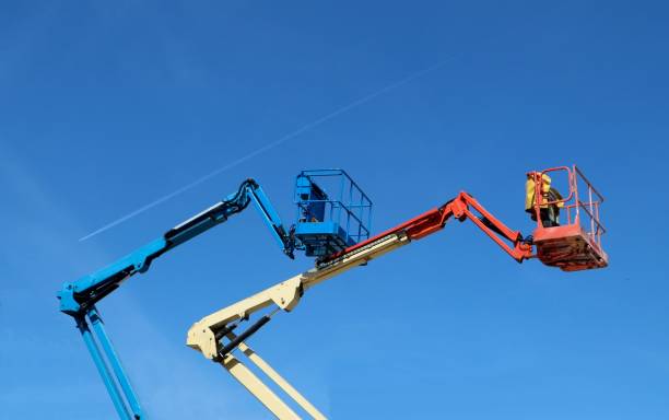 istock Two aerial work platforms of cherry picker against blue sky 1187769753