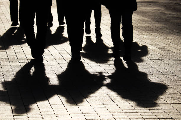 silhouettes et ombres de personnes sur la rue de ville - gangster photos et images de collection