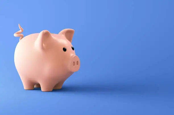 Photo of Pink piggy bank on blue background