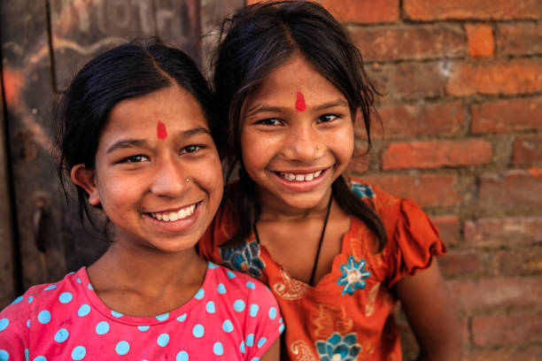 Happy Indian girls posing in Bhaktapur, Kathmandu Valley. Bhaktapur is an ancient Newar town in the east corner of the Kathmandu Valley, Nepal. It is the third largest city in Kathmandu valley and was once the capital of Nepal during the great Malla Kingdom until the second half of the 15th century. Bhaktapur is listed as a World Heritage by UNESCO for its rich culture, temples, and wood, metal and stone artwork.