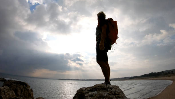 istock Mountaineer ascends to rock summit at sunrise 1187772806