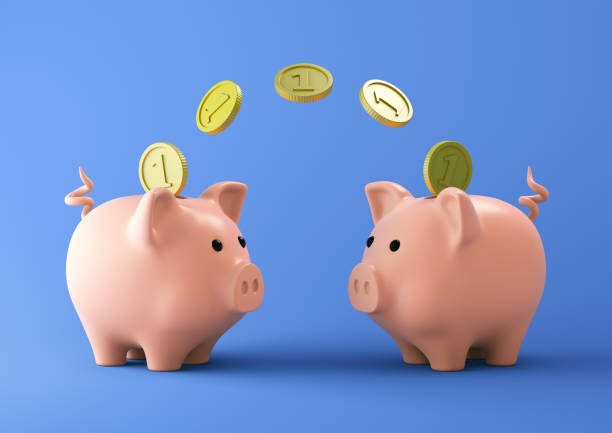 파란색 배경에 동전이있는 두 개의 분홍색 돼지 저금통 - exchanging money 뉴스 사진 이미지
