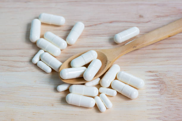 istock the white many capsules on wood table 1187773909