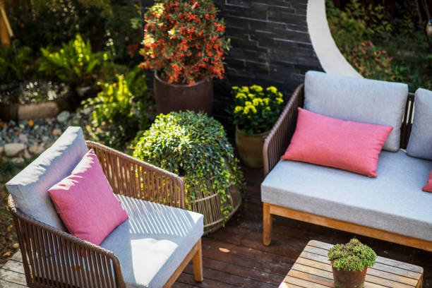 An inviting outdoor lounge area features two comfortable sofas with light cushions and a rustic dark wooden table