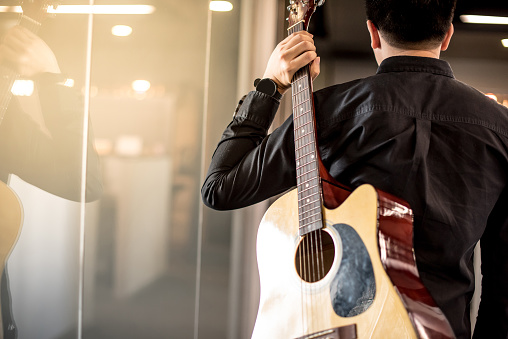 Guitarrista masculino sosteniendo guitarra acústica photo
