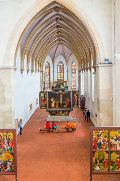 Colmar, France - July 3, 2013: people visit the Isenheim Altarpiece, sculpted and painted by the Germans Niclaus of Haguenau and Matthias Gruenewald in 1512–1516 in Colmar, France.