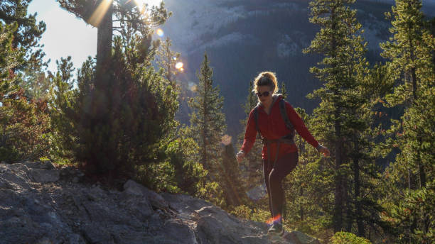 istock Young female hiker ascends mountain through forest 1187779090