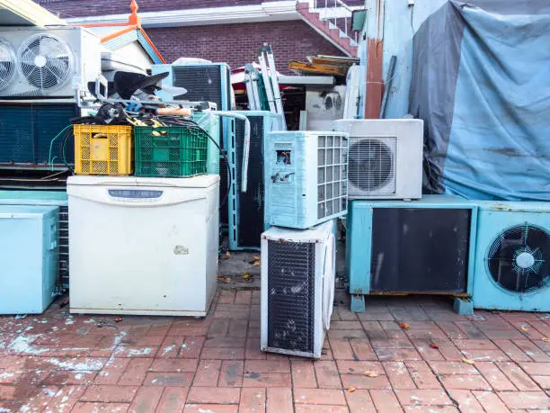 many old air conditioners and refrigerators on street near repair shop in Sokcho city, South Korea