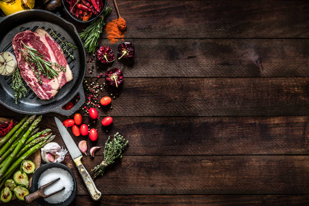 asar un filete de ternera y verduras en una parrilla de hierro con espacio de copia en la mesa - veal meat raw steak fotografías e imágenes de stock