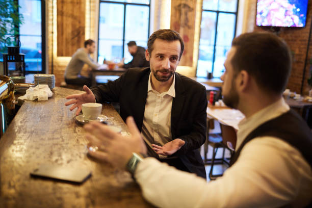 After Work Portrait f two handsome gentlemen enjoying coffee in cafe chatting while sitting by bar counter, copy space bar drink establishment stock pictures, royalty-free photos & images