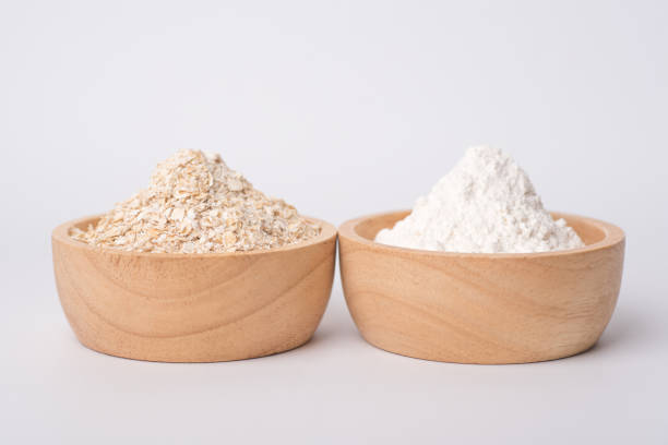 Close up of oat flake and wheat flour prepared for cooking on a white background stock photo