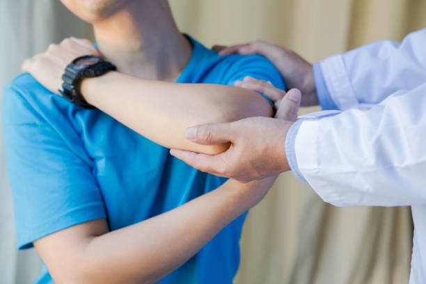 istock muscular man with shoulder ache exercising with physiotherapist 1187793943