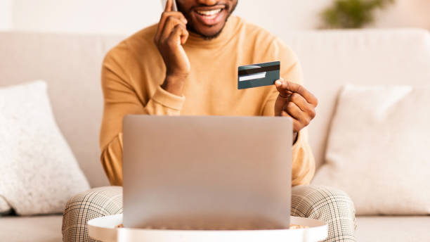 istock Guy Calling To Bank Using Credit Card And Laptop Indoor 1187795819