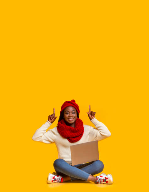 istock Excited black girl with laptop pointing up at empty space 1187795917
