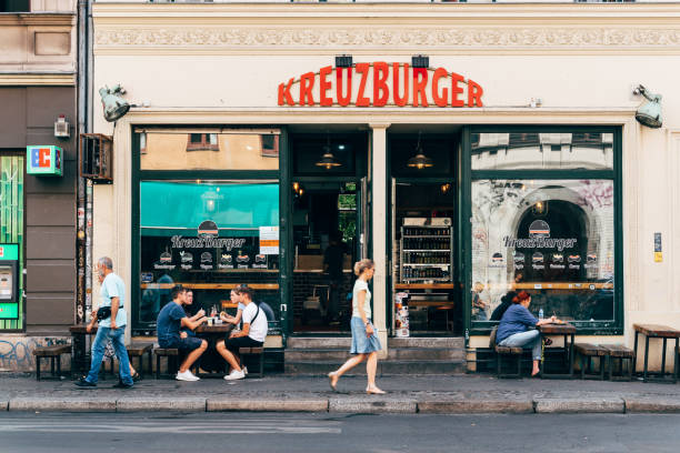 модный ресторан со столами и зонтиками на тротуаре в квартале кройцберг. - berlin kreuzberg фотографии стоковые фото и изображения